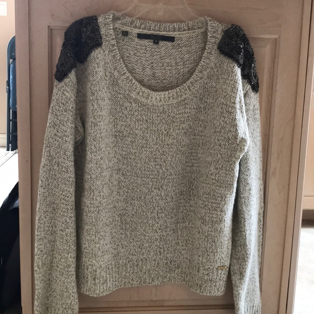 Pullover sweater with shoulder appliqués.